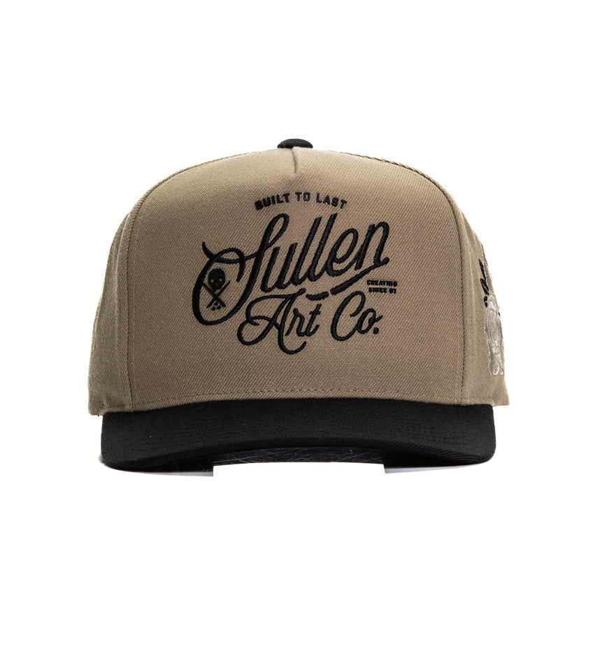 Beige and black cap with 'SULLEN Art Co.' logo on a white background