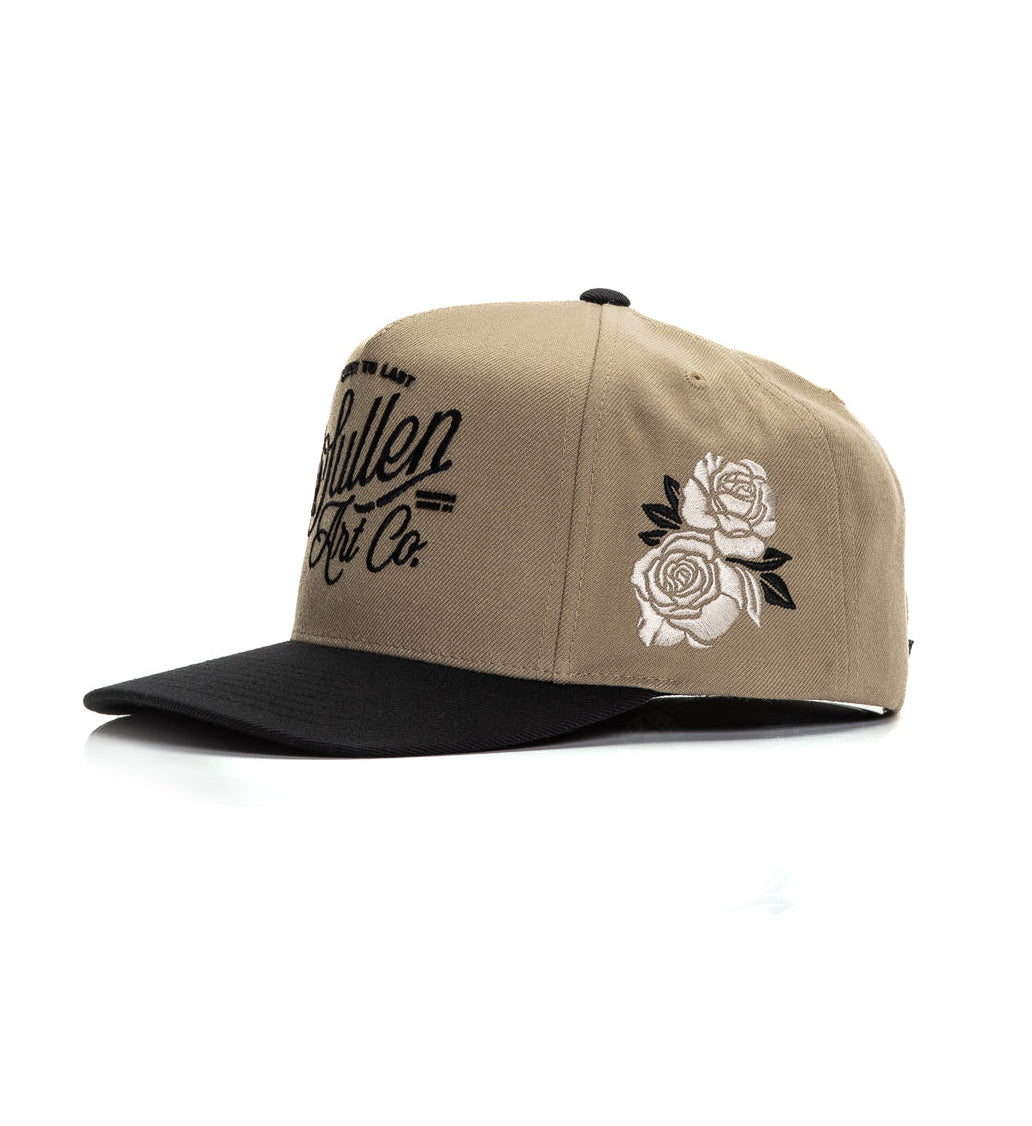 Beige cap with black visor and floral design on a white background