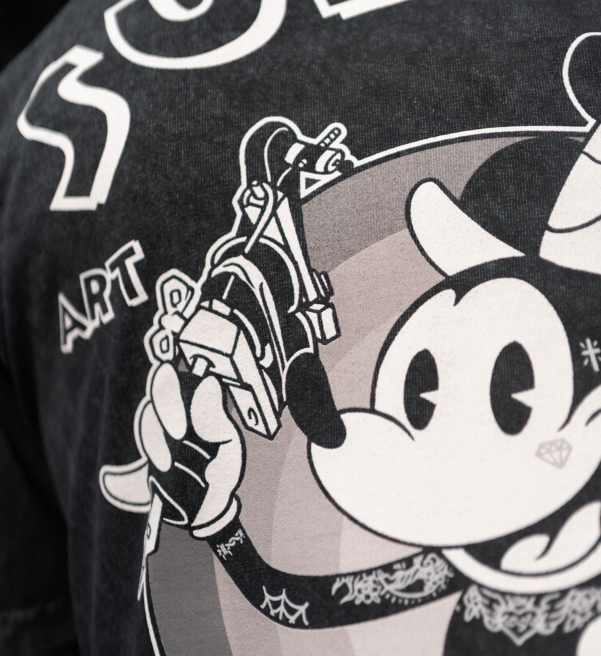 Black t-shirt with a graphic design of a skeleton hand holding a gun and a stylized face.