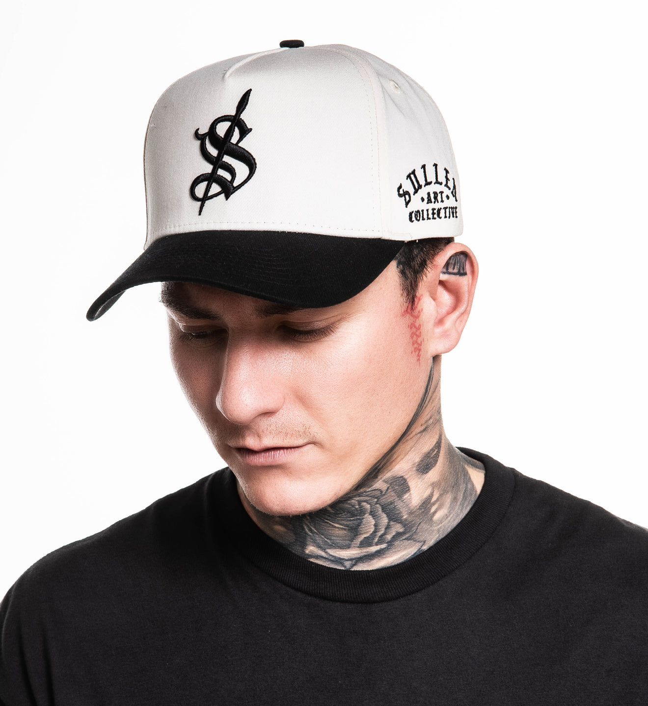 Person wearing a white and black cap with a logo on a white background