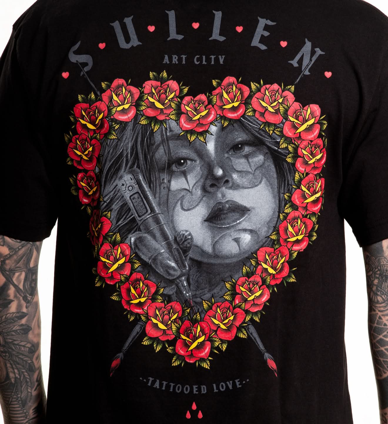 Black t-shirt with a graphic design of a face with flowers and a gun, brand 'Sullen' visible.