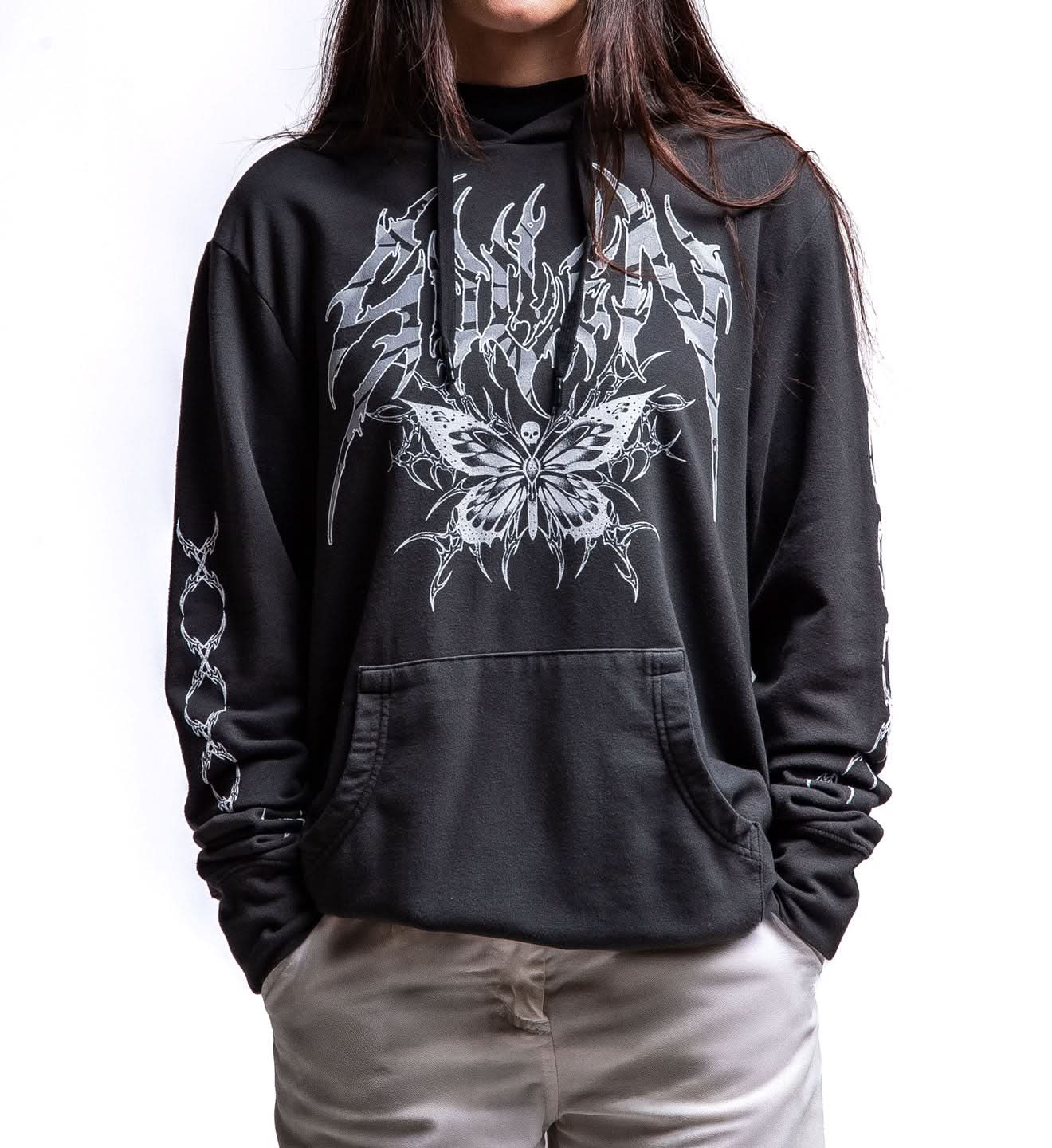 Person wearing a black hoodie with white butterfly design on a plain background