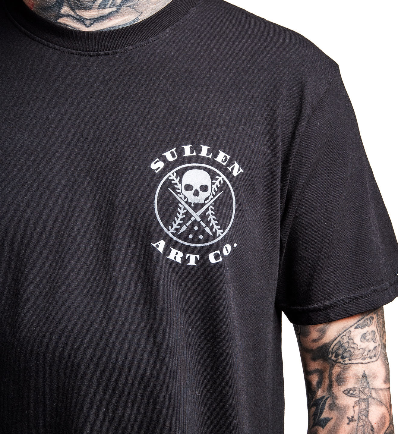 Black t-shirt with 'Sullen Art Co.' logo worn by a person with tattoos.