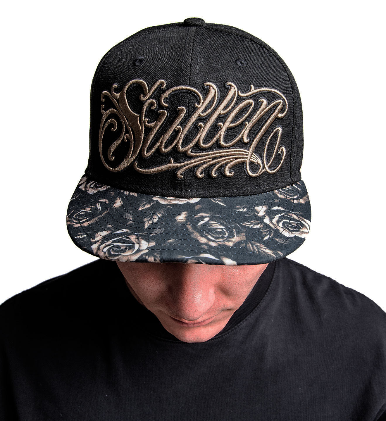 Black cap with floral pattern on the front and 'Sullen' logo on a white background