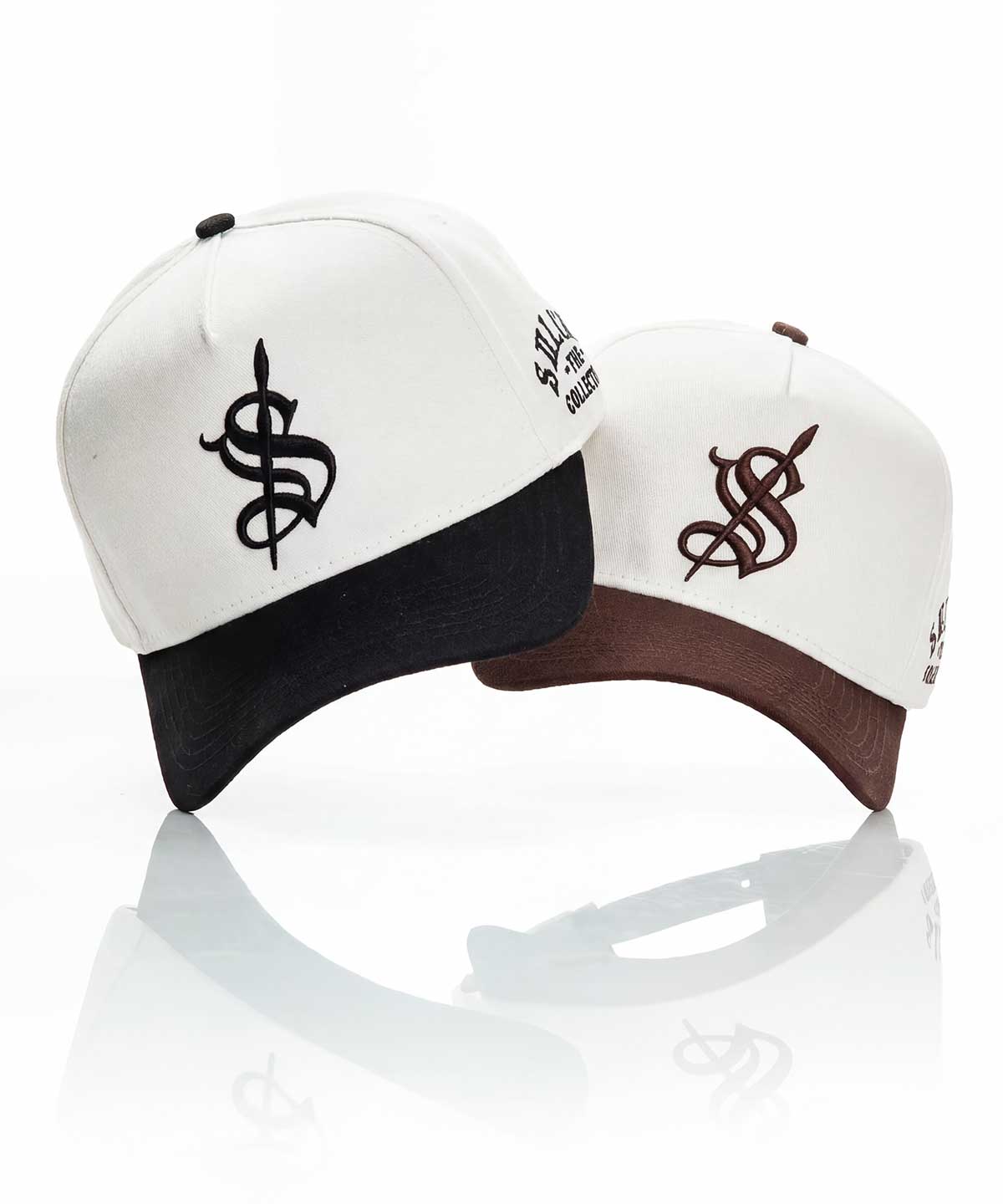 Two white caps with black and brown visors featuring a logo on a reflective white surface.