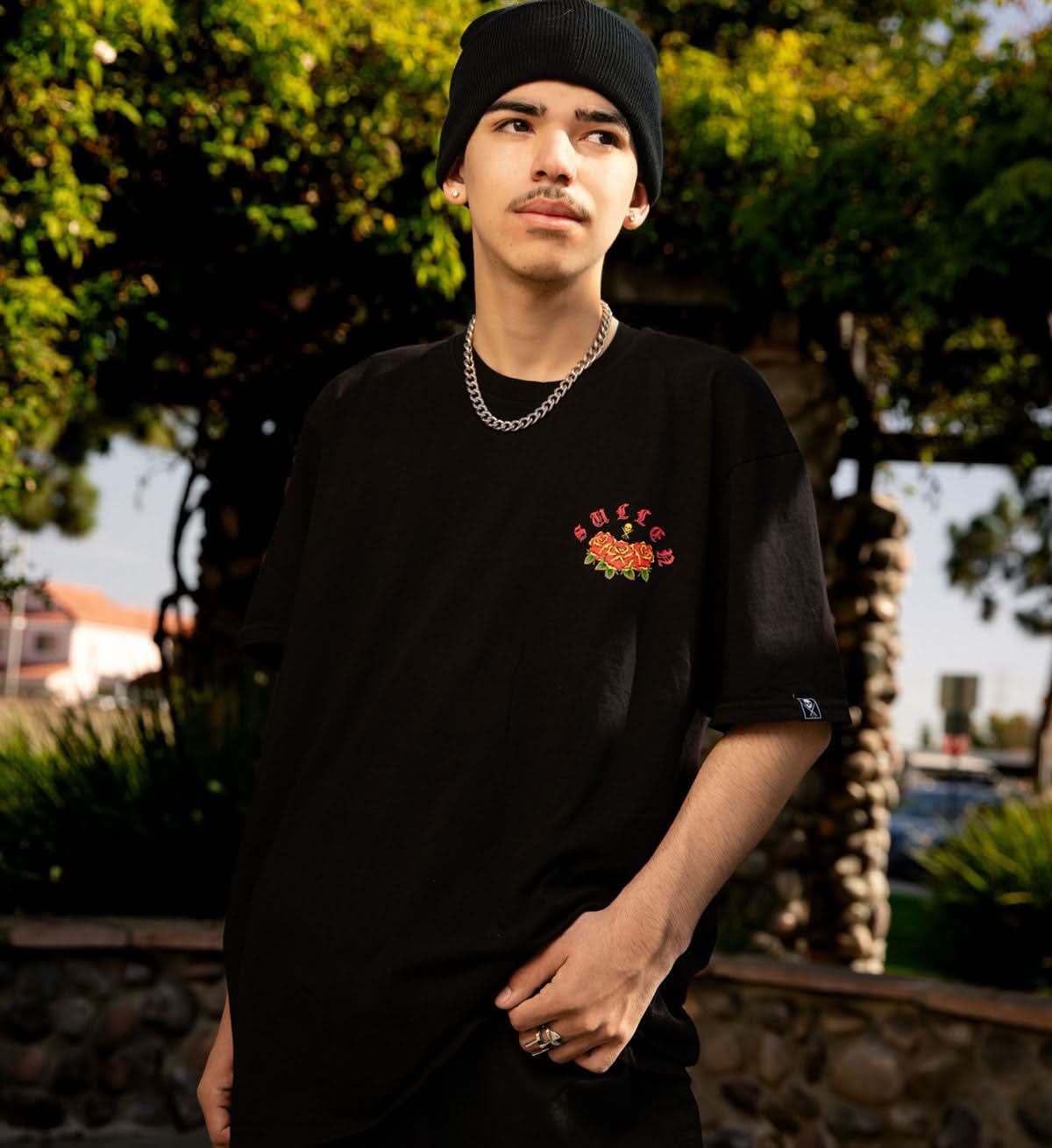 Person wearing a black t-shirt with a floral design outdoors